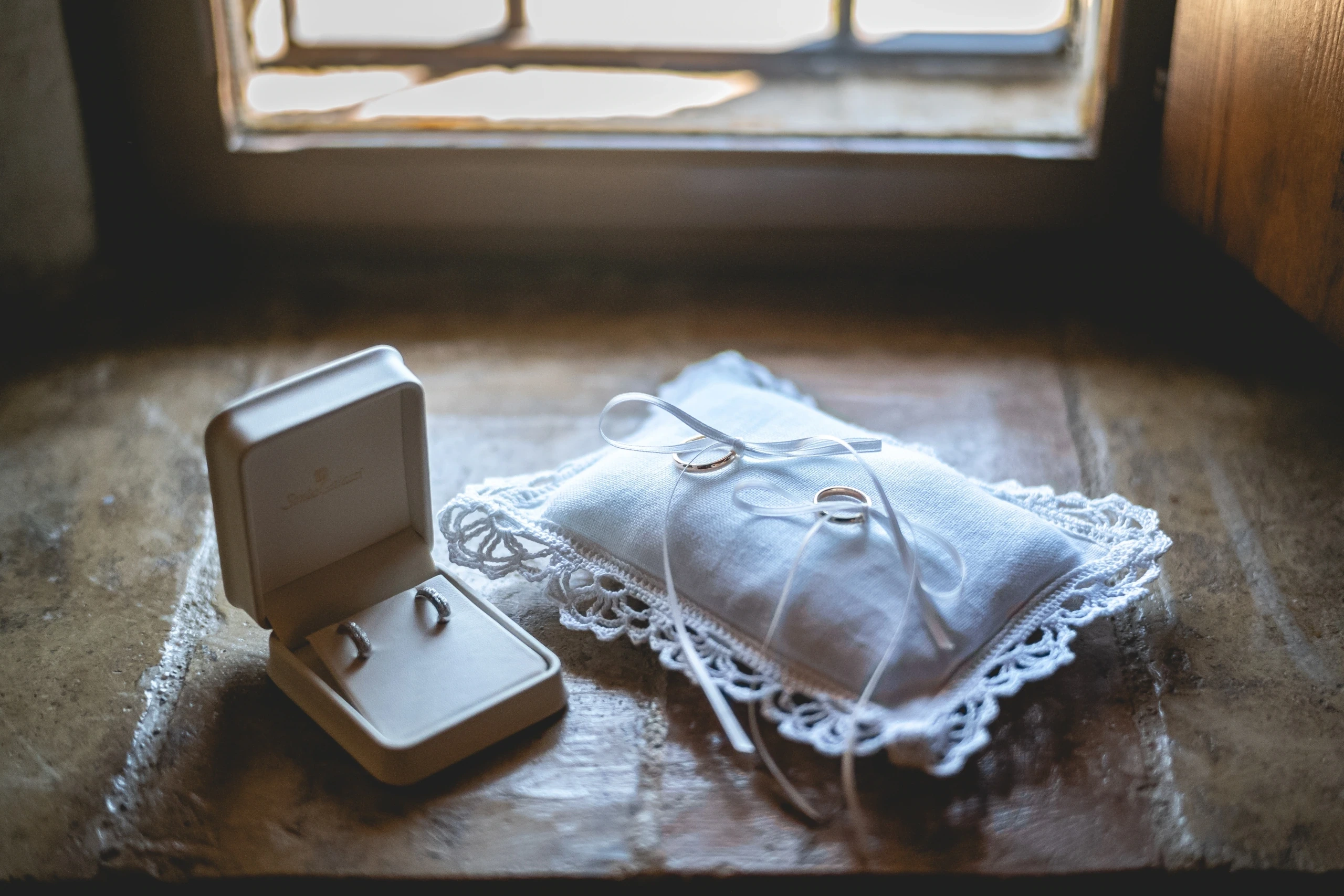 The rings in their box and on the lace cushion, beside the window.