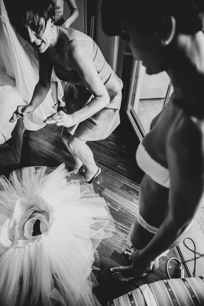 From above, hands at the tulle underskirt and the shoes.