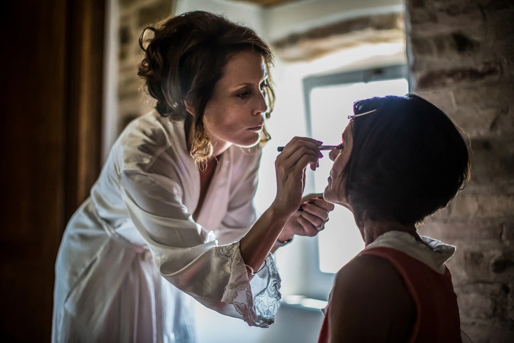 Make-up, at the window of a stone house.