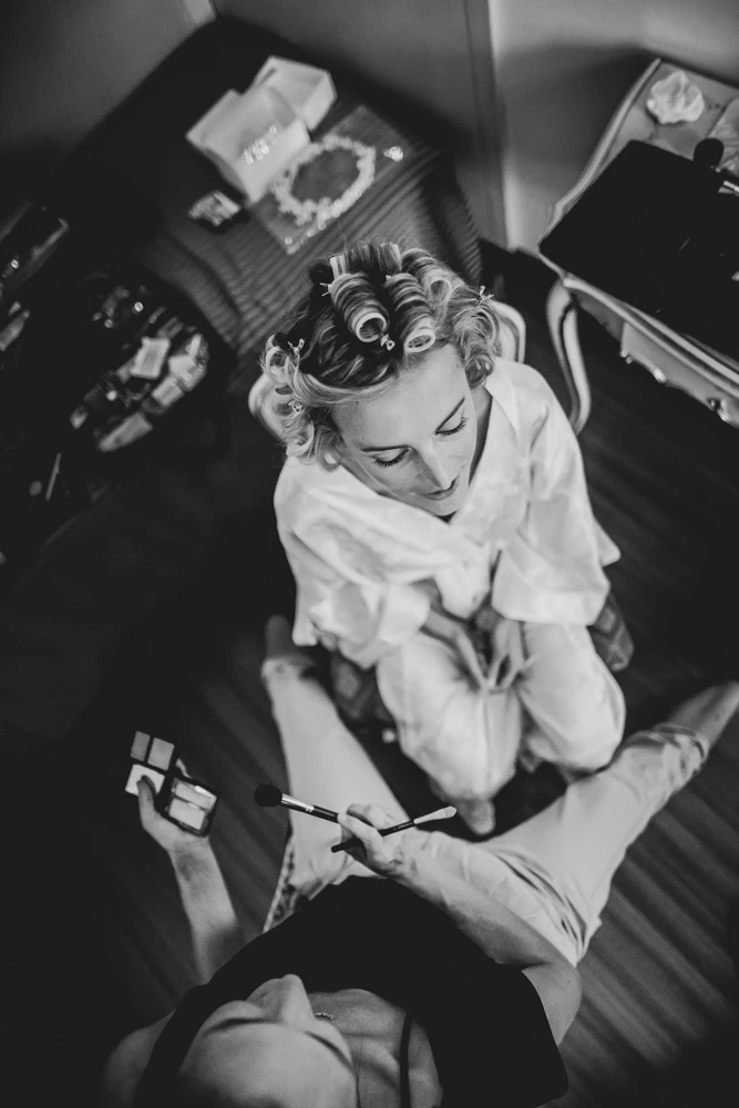 From above, the bride in curlers while her feet are tended.