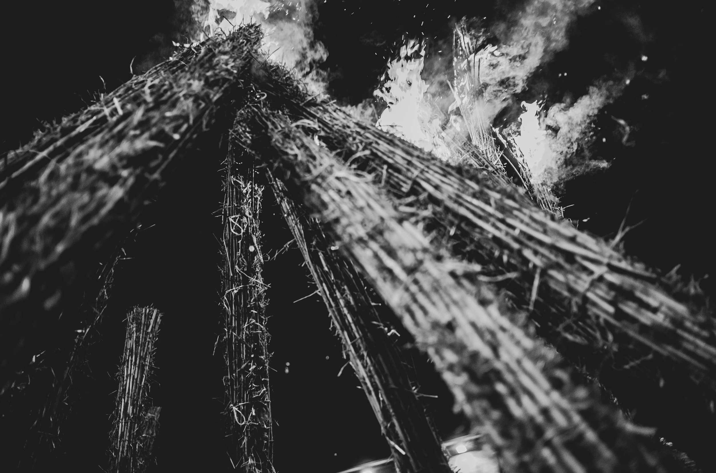 Close up, the stacked bundles of cane burning.