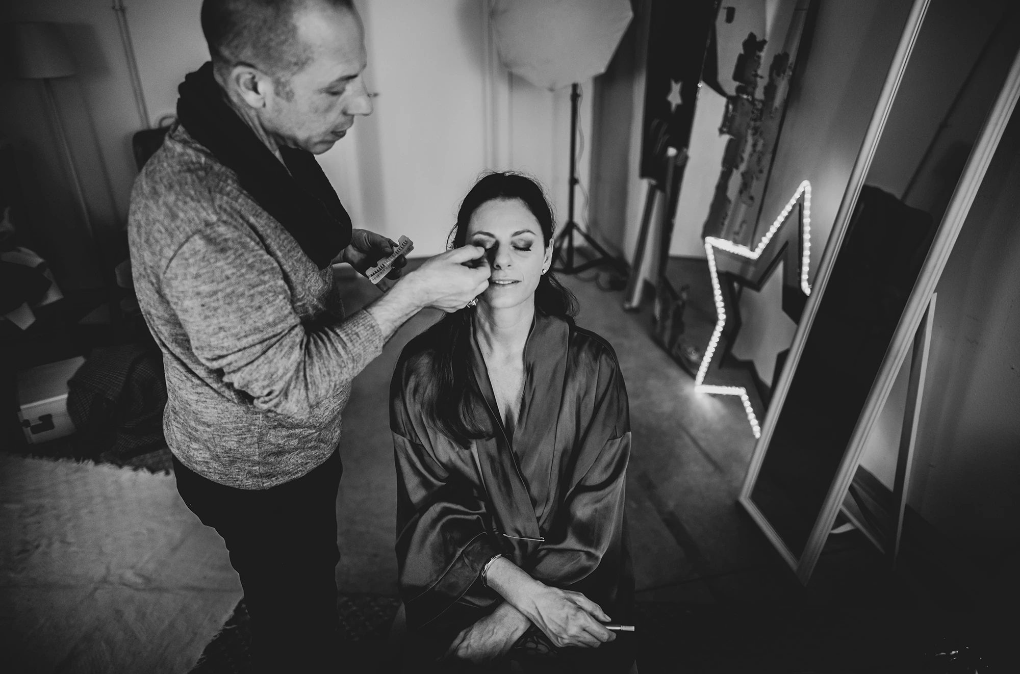 In a robe, the bride made up beside the illuminated star.