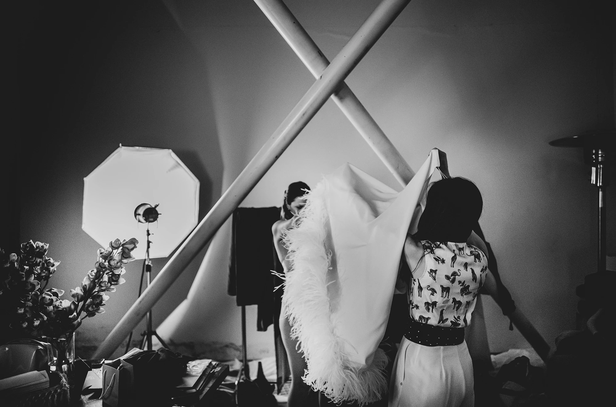 In the room set up with lights, the bride in a feather stole.