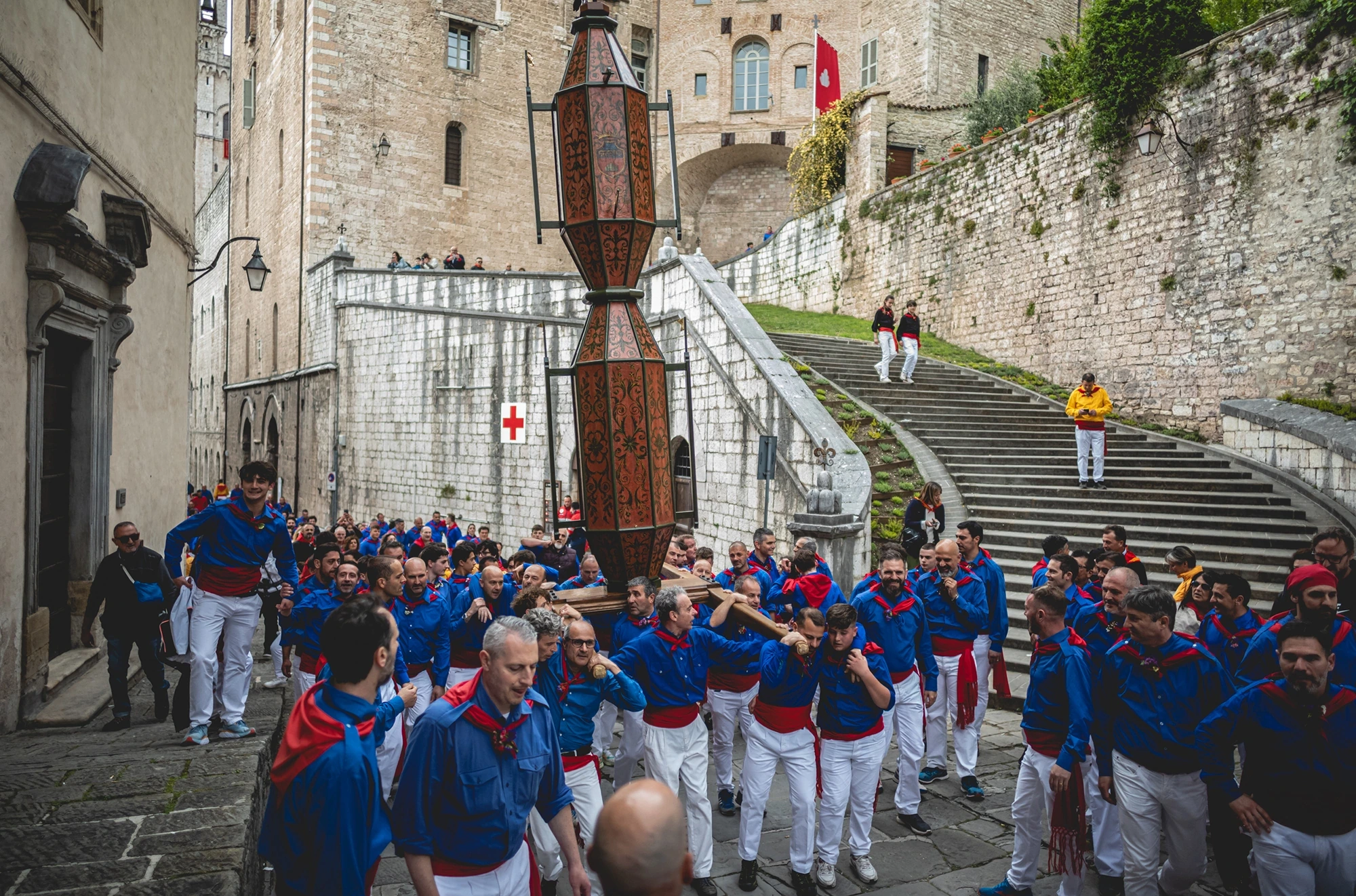 The cero standing in the street, the ceraioli in blue gathered beneath it.