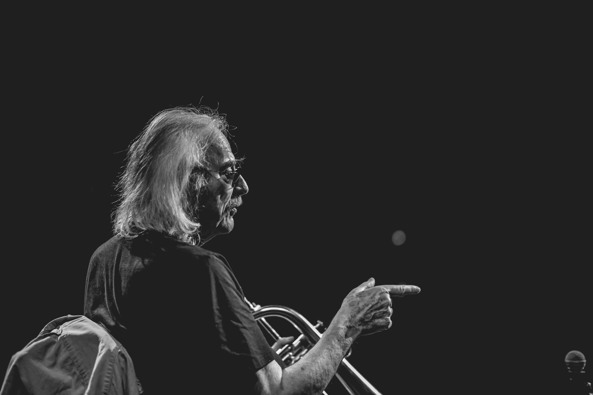 Trumpet in hand, a gesture towards someone beyond the stage.