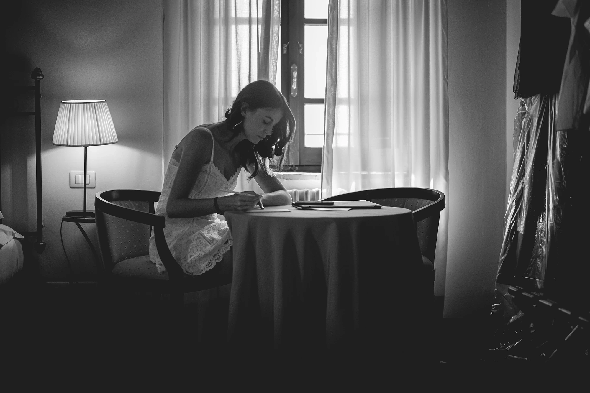 At the desk by the window, the bride writes.