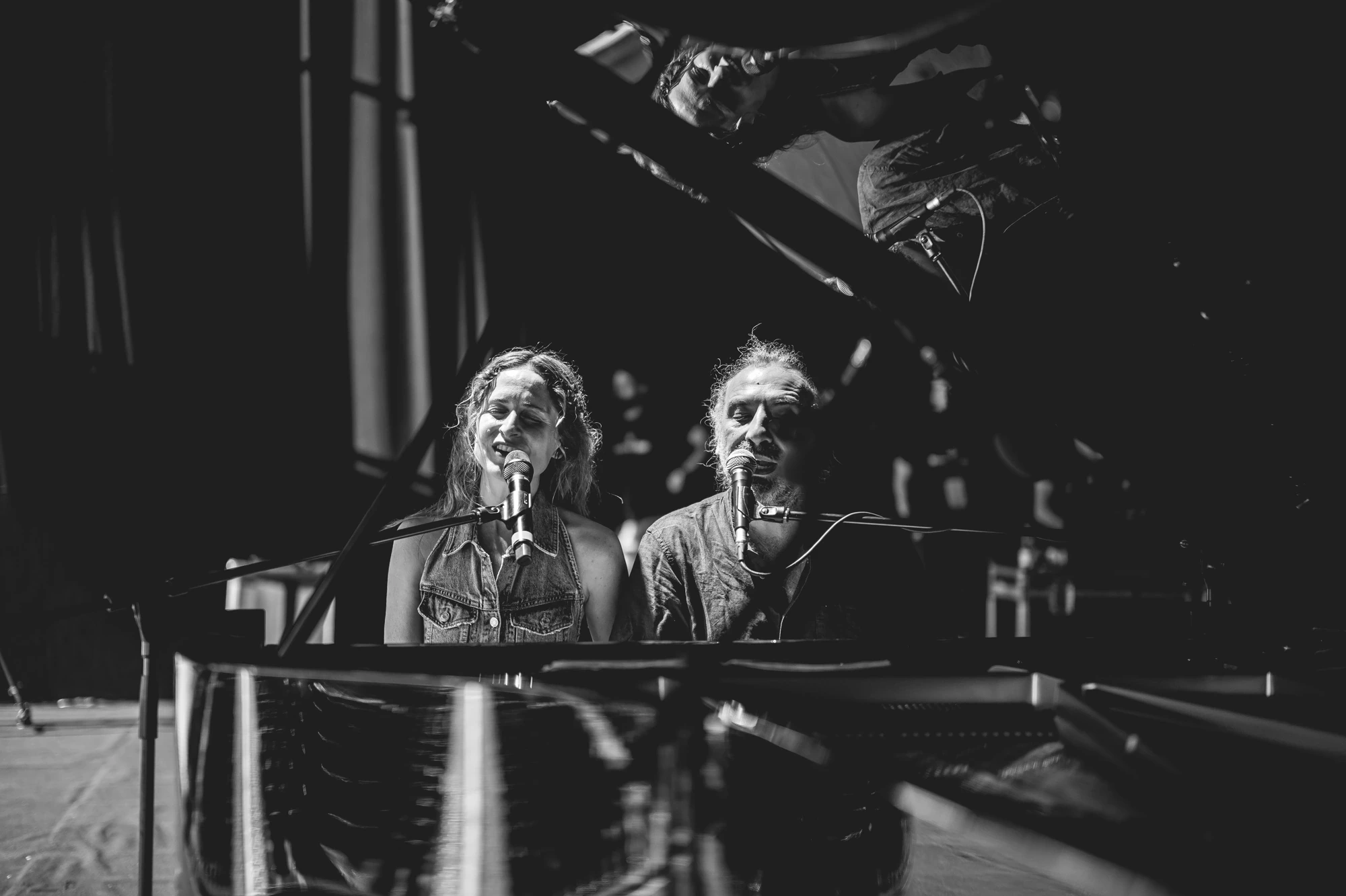 Two voices at the microphones, behind the piano.
