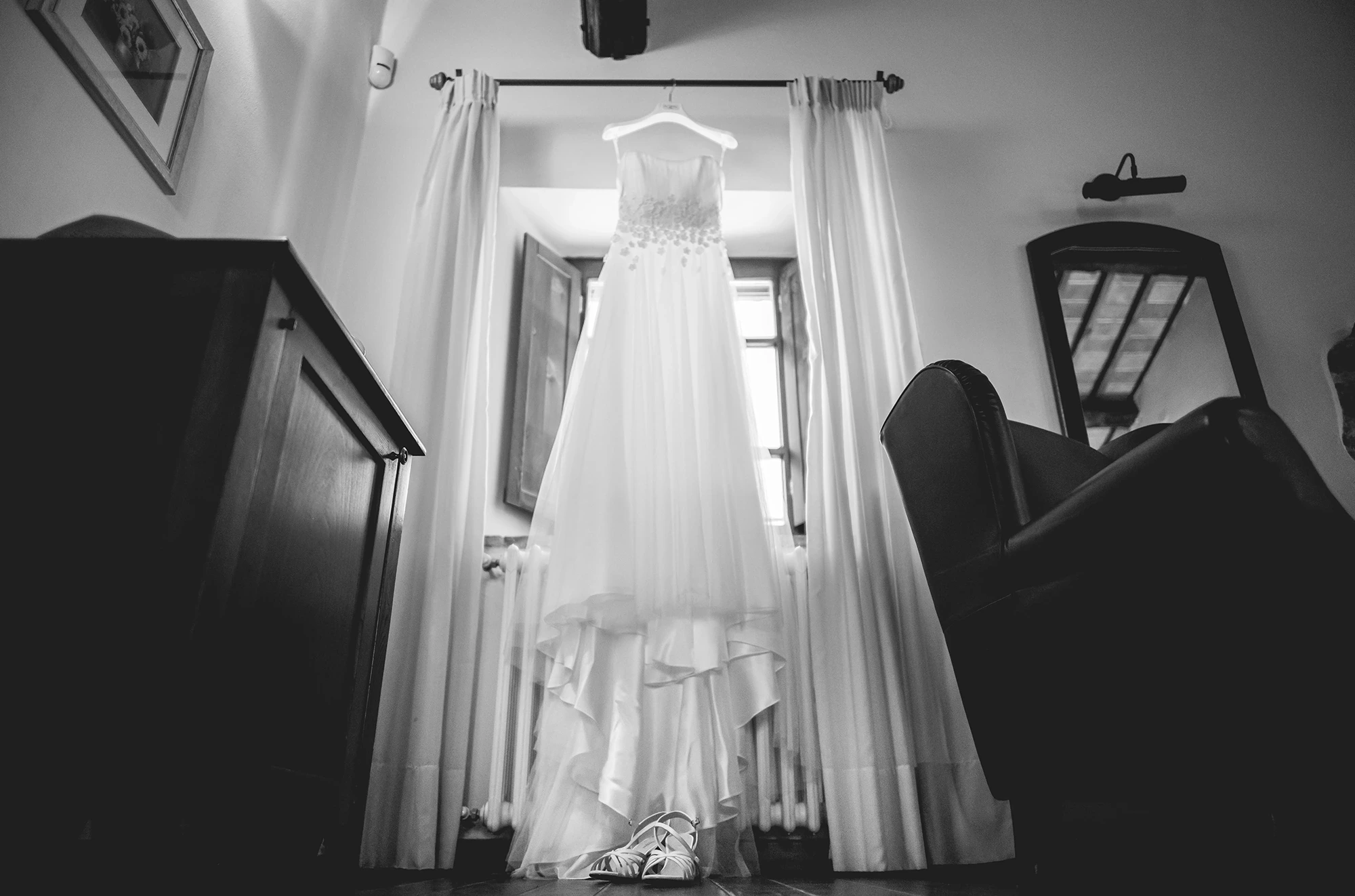 The dress hanging in the window, between wardrobe and mirror.