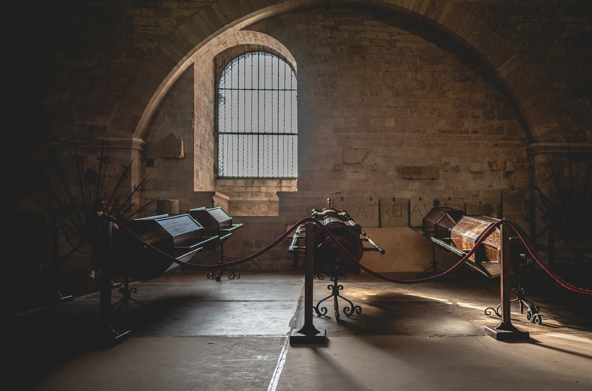 An empty vaulted hall, the feast's fittings displayed beyond a rope.