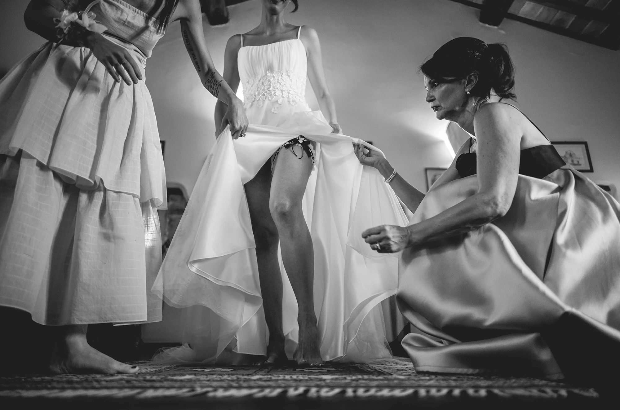 Hands lift the skirt to arrange the dress.