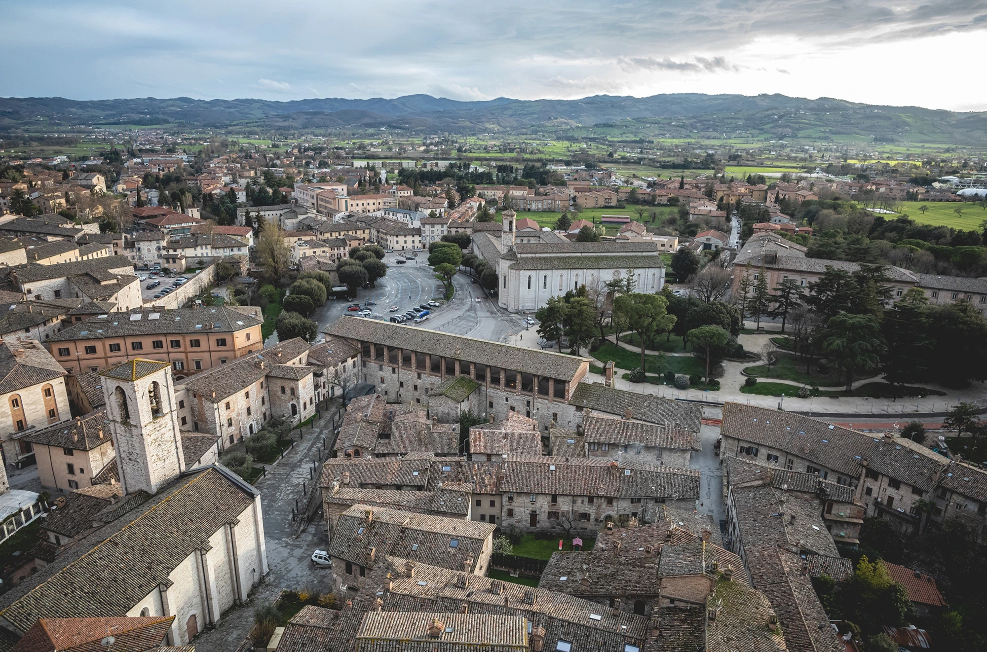 From above, the town's roofs and the plain beyond the walls.