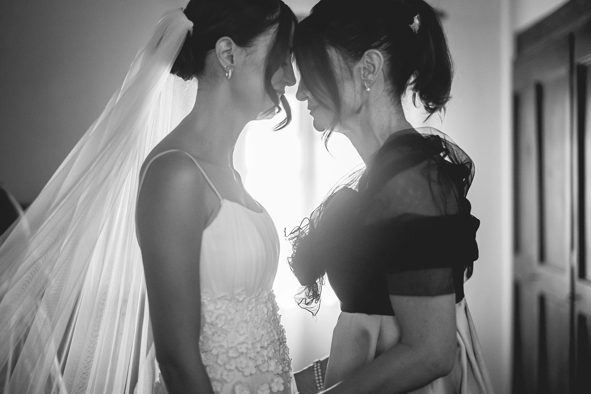 Forehead to forehead with a woman, the veil backlit.