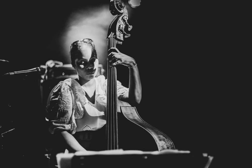 At the double bass, in front of the microphone.