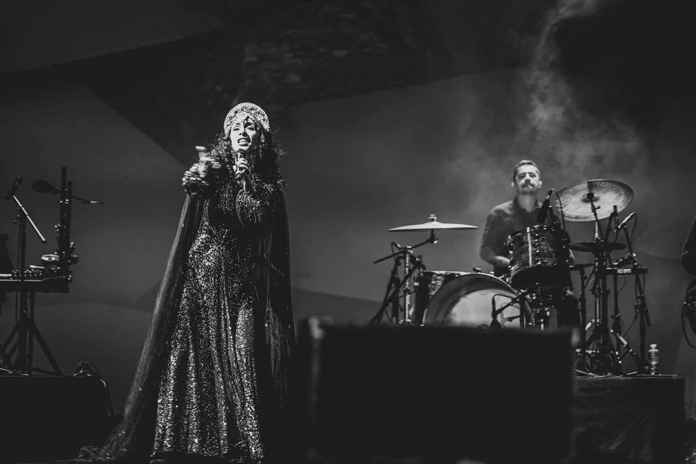 In a long sequinned gown on stage, the drums behind.