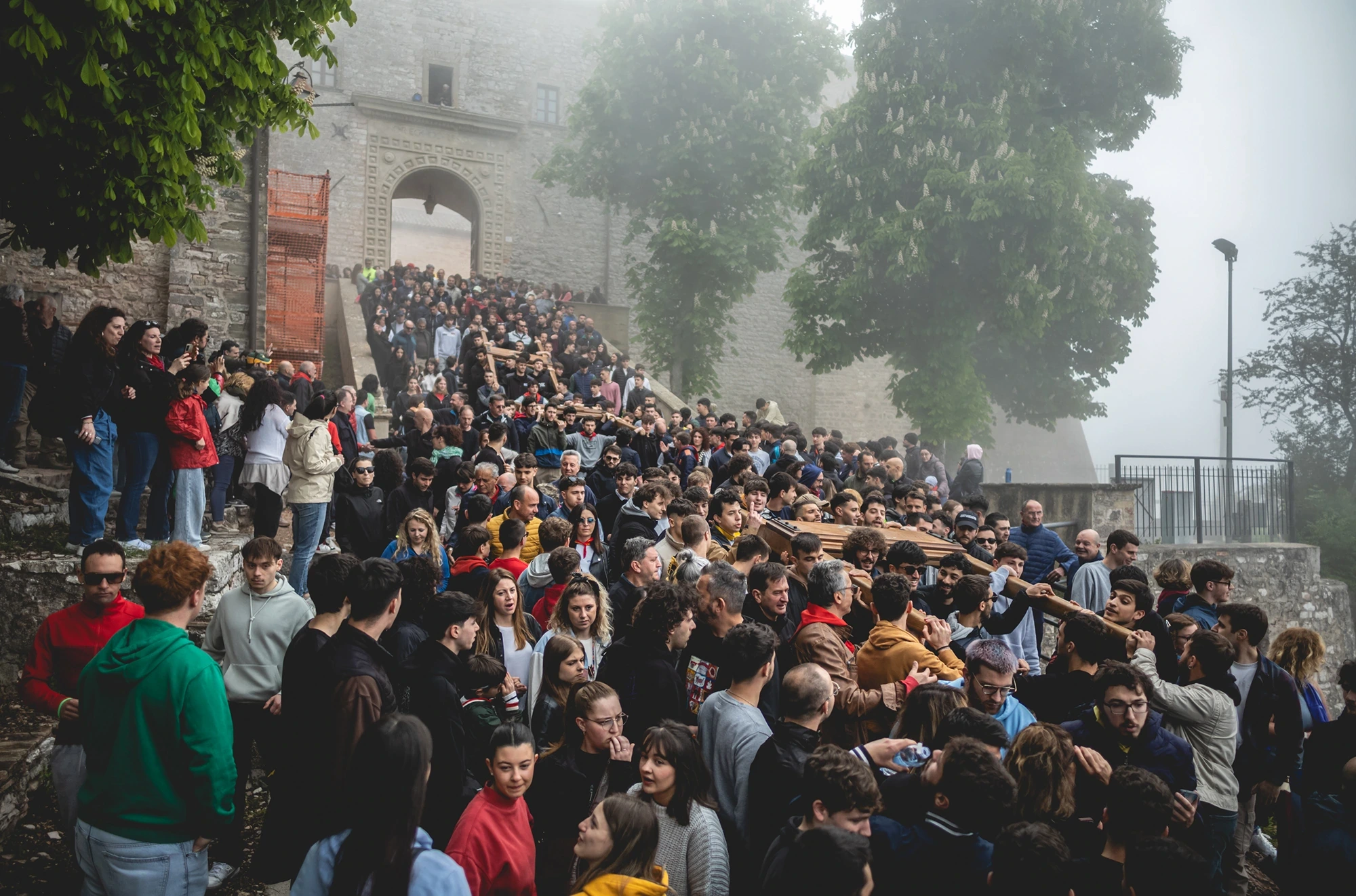 In the mist, the crowd on the steps in front of the church.