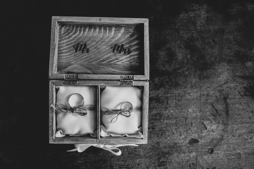 The wooden box with the rings, propped against the rough wall.