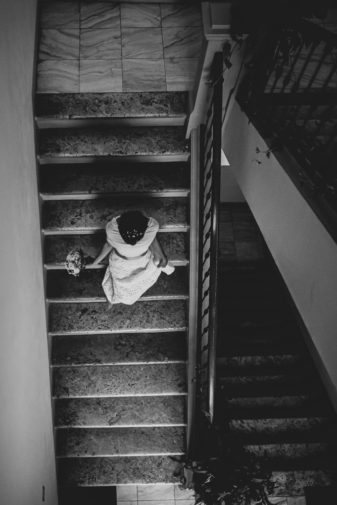 From above, a girl in white sitting on the marble steps.