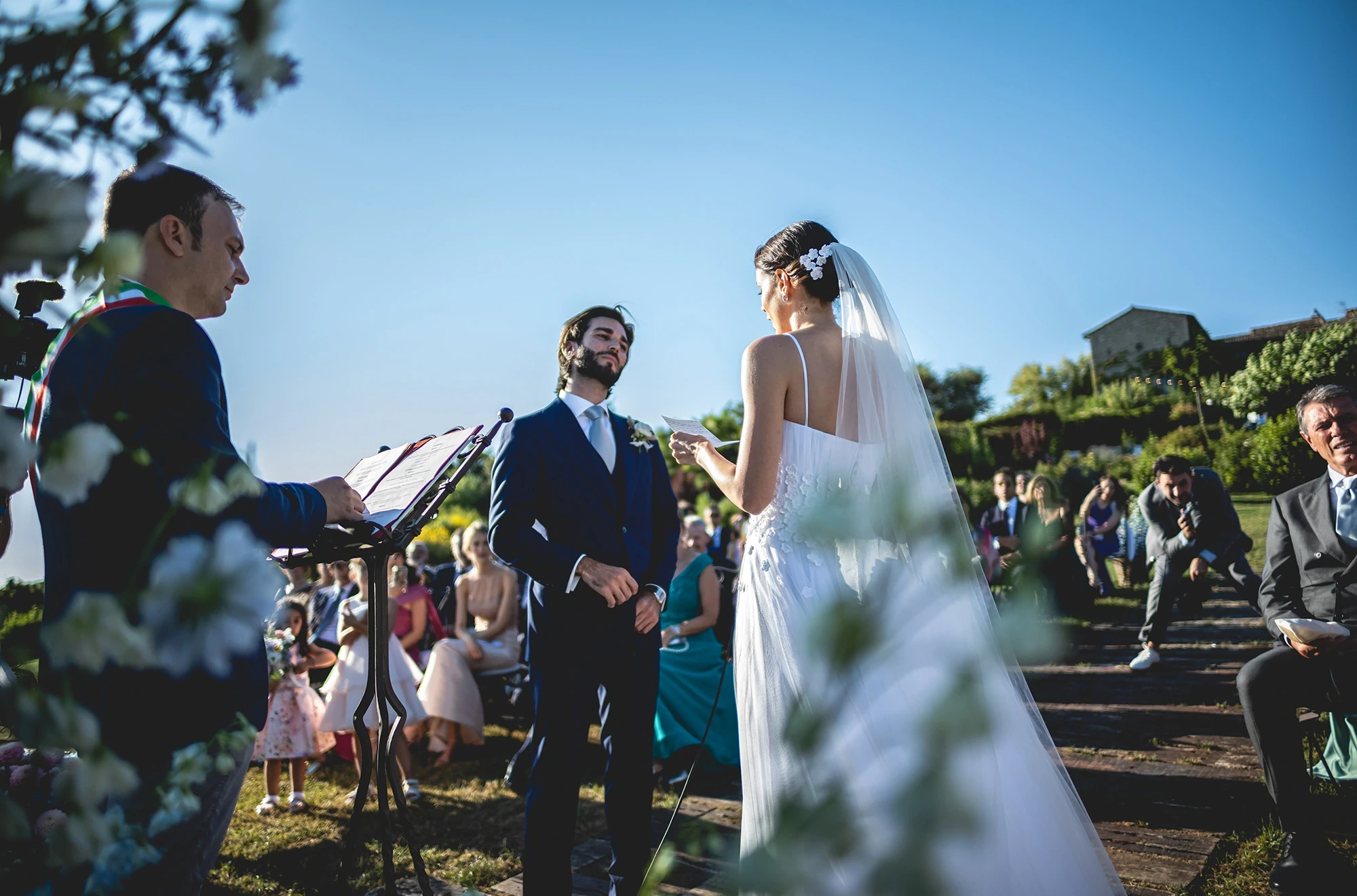 An outdoor ceremony, the couple facing each other.