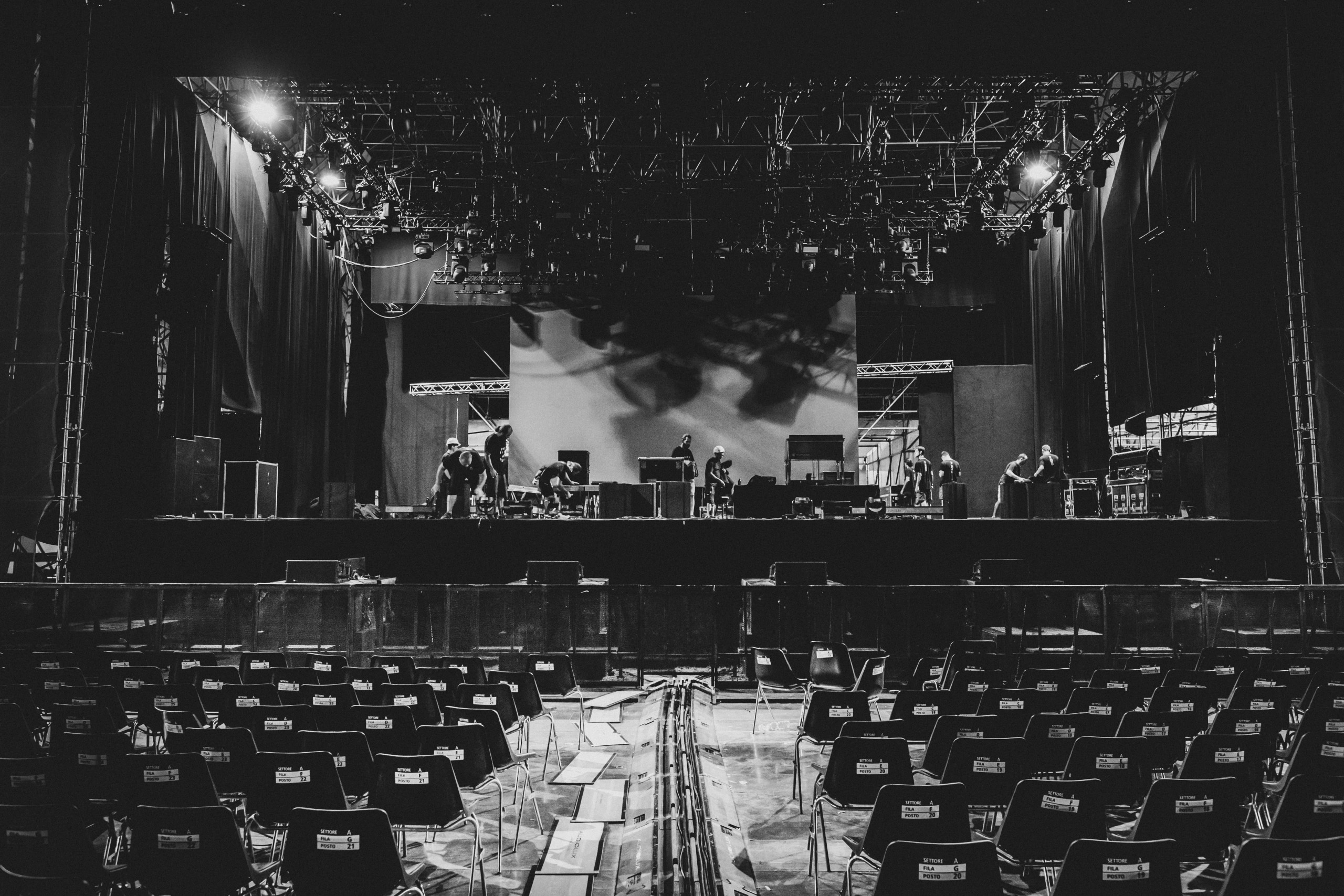 Rows of empty chairs before the stage, before the audience comes in.