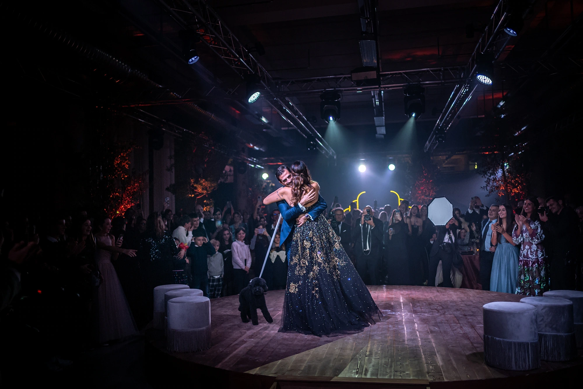 Dancing in the darkened hall, surrounded by the guests.