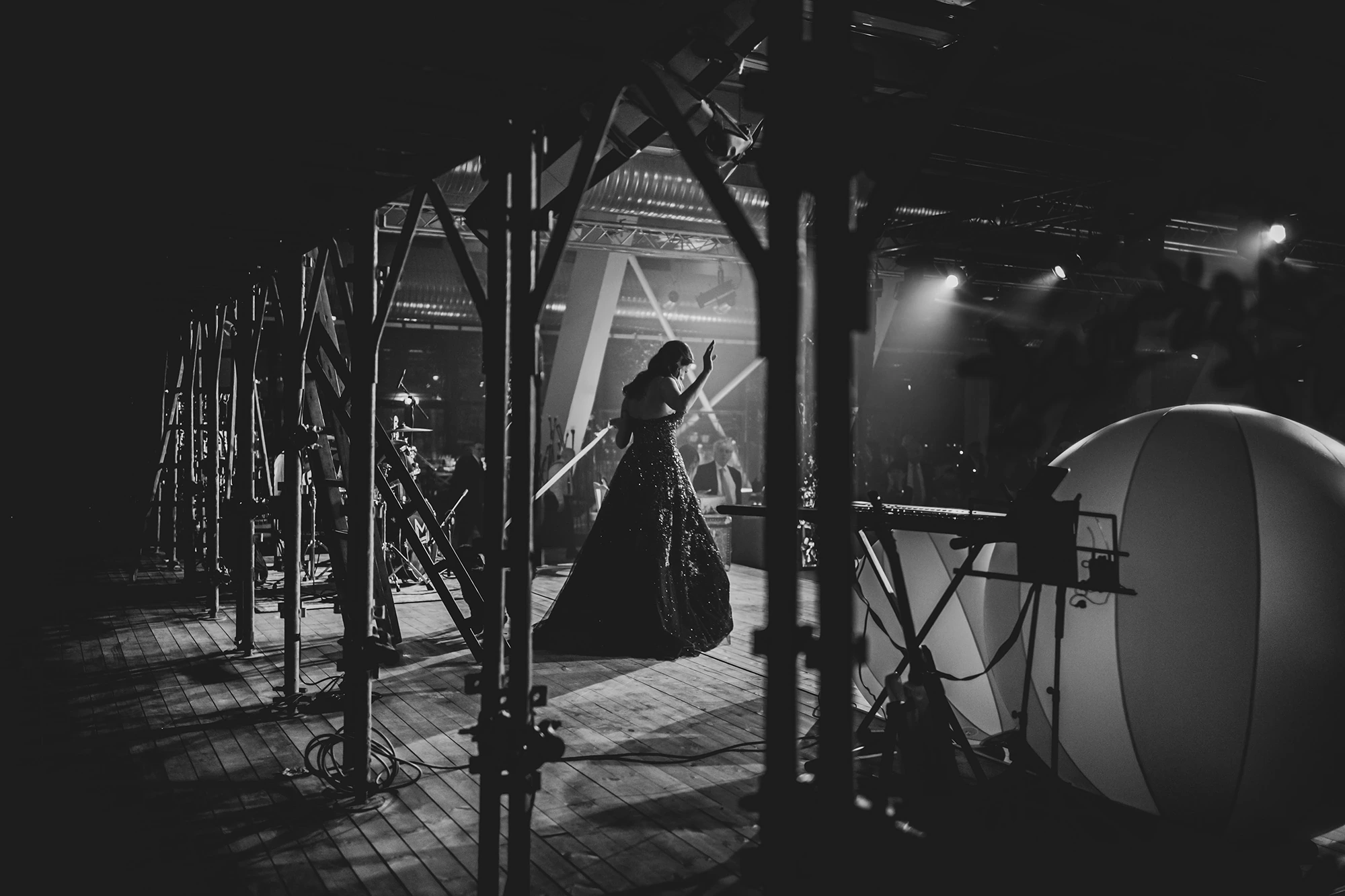 On the stage among the lights, a figure in a long gown.