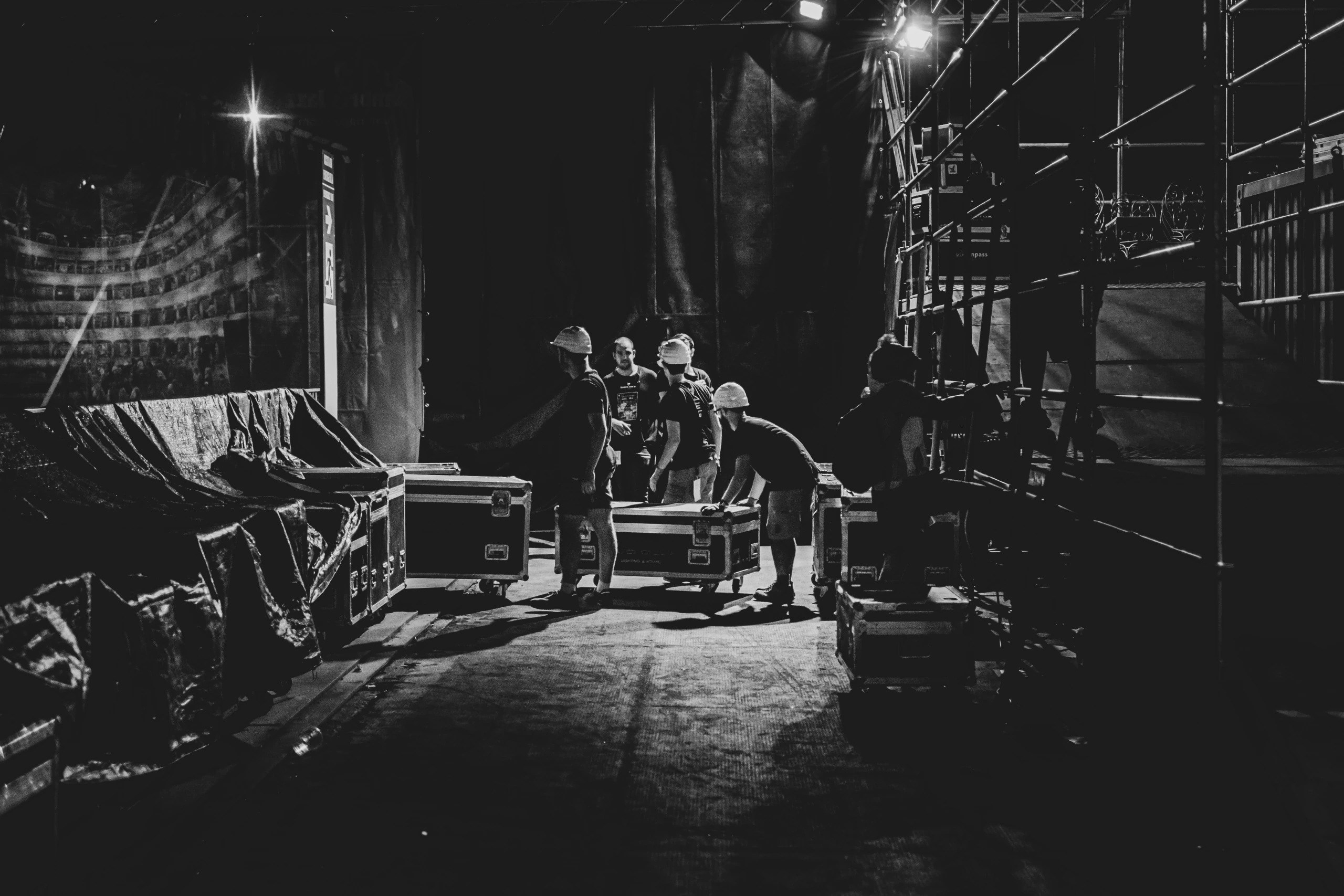 At night, the crew push cases along the corridor beside the stage.