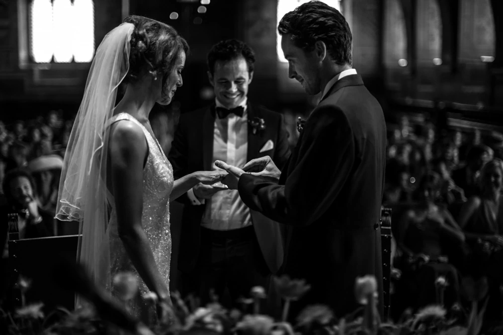 The exchange of rings, the celebrant between them.
