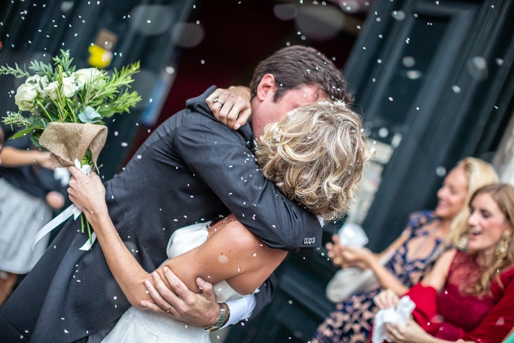In an embrace under the rice, her face hidden on his shoulder.