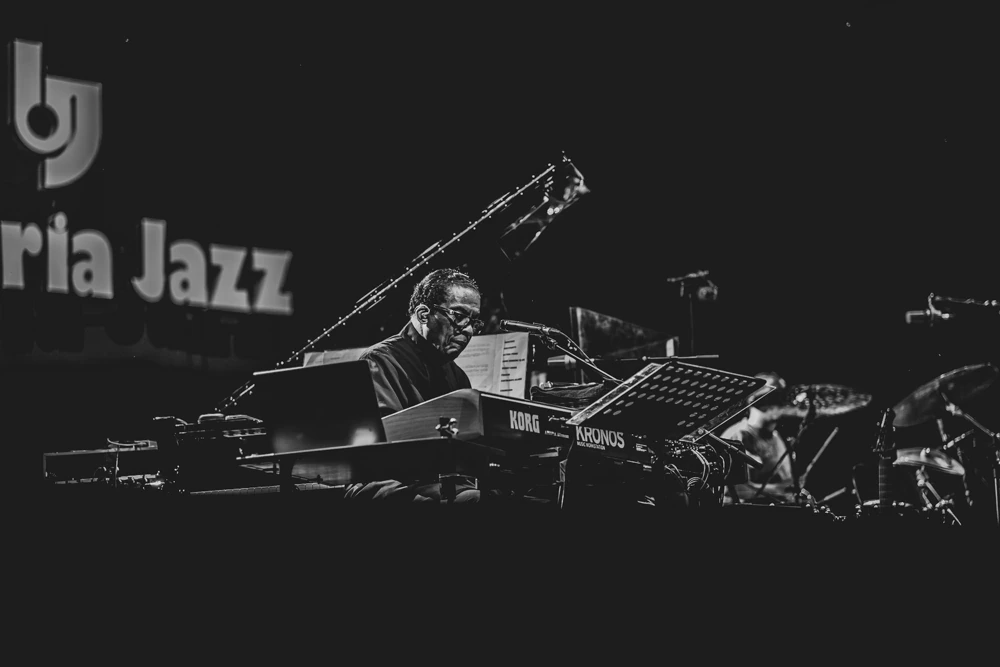 At the keyboards beneath the festival sign.