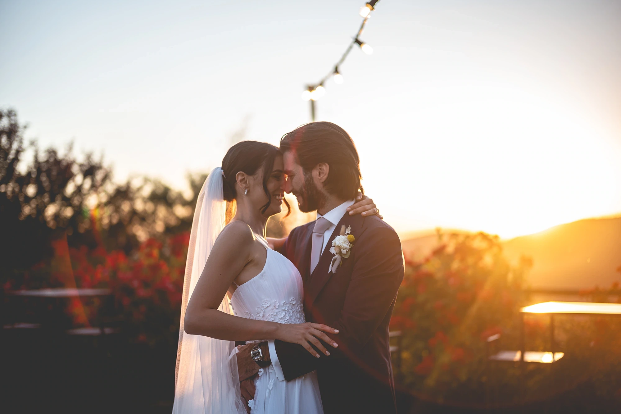 At sunset, face to face beneath the hanging lights.