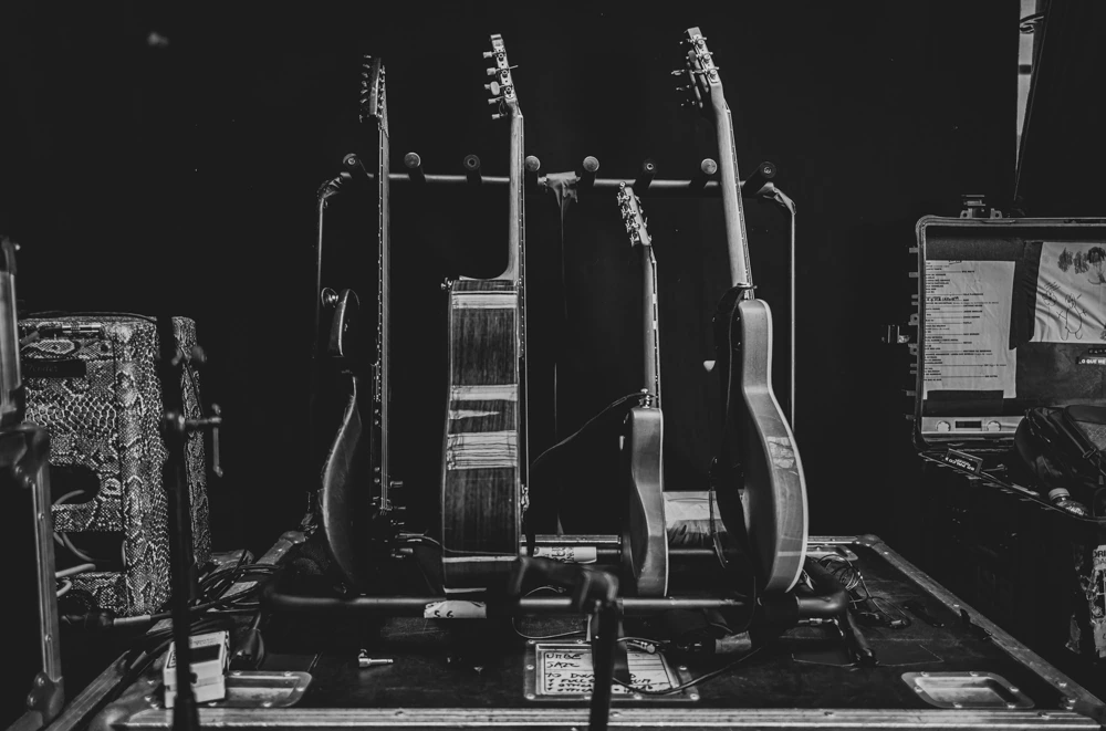 Backstage, the guitars lined up on their stand.