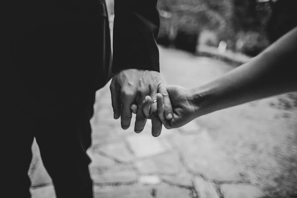 Hands clasped as they walk over the paving.