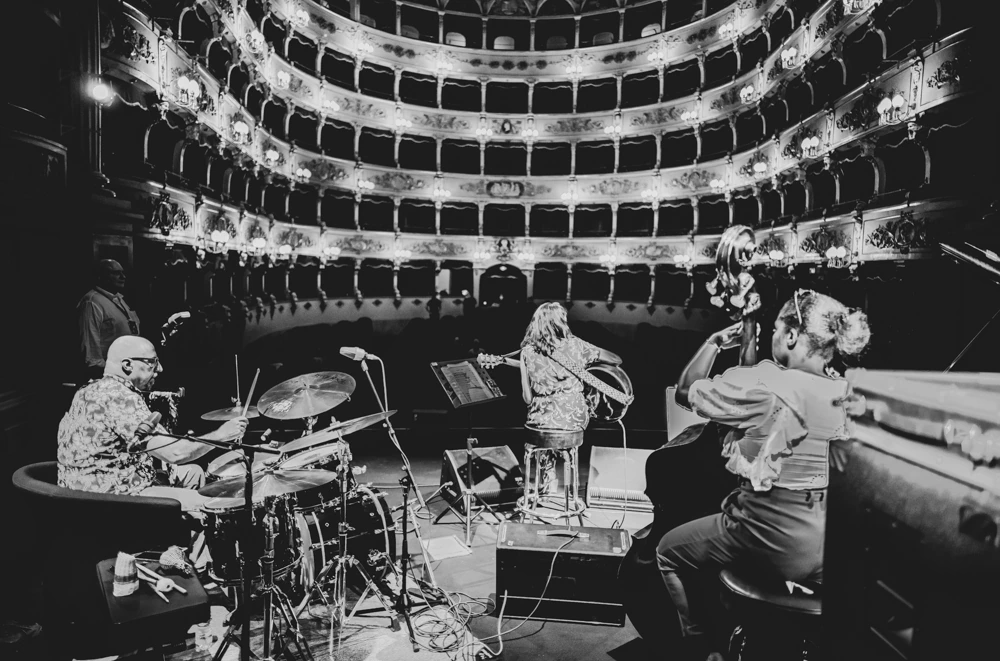 Rehearsal on the theatre stage, tiers of boxes behind.