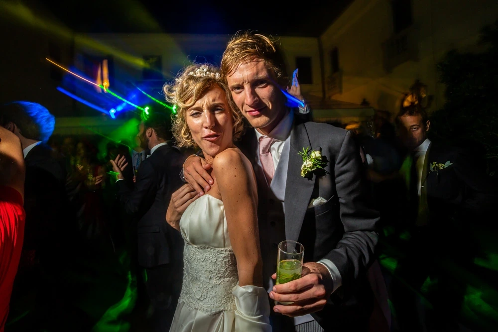 Among the laser lights, the couple with a drink in hand.