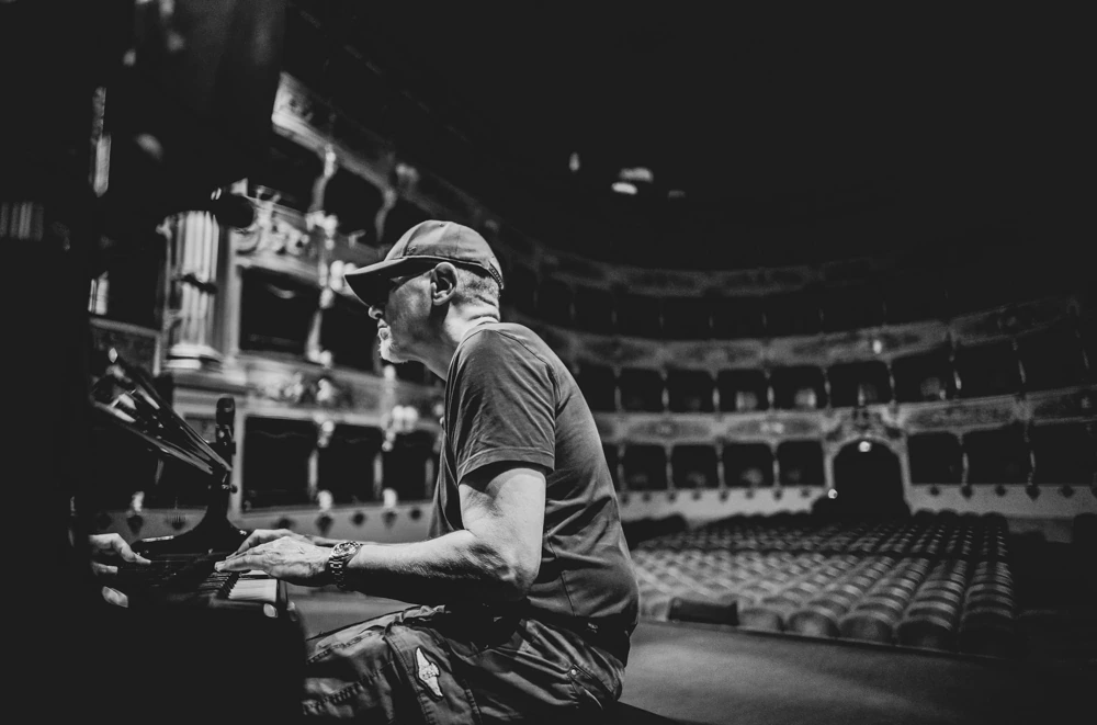At the desk in the empty theatre, a technician sets the sound.