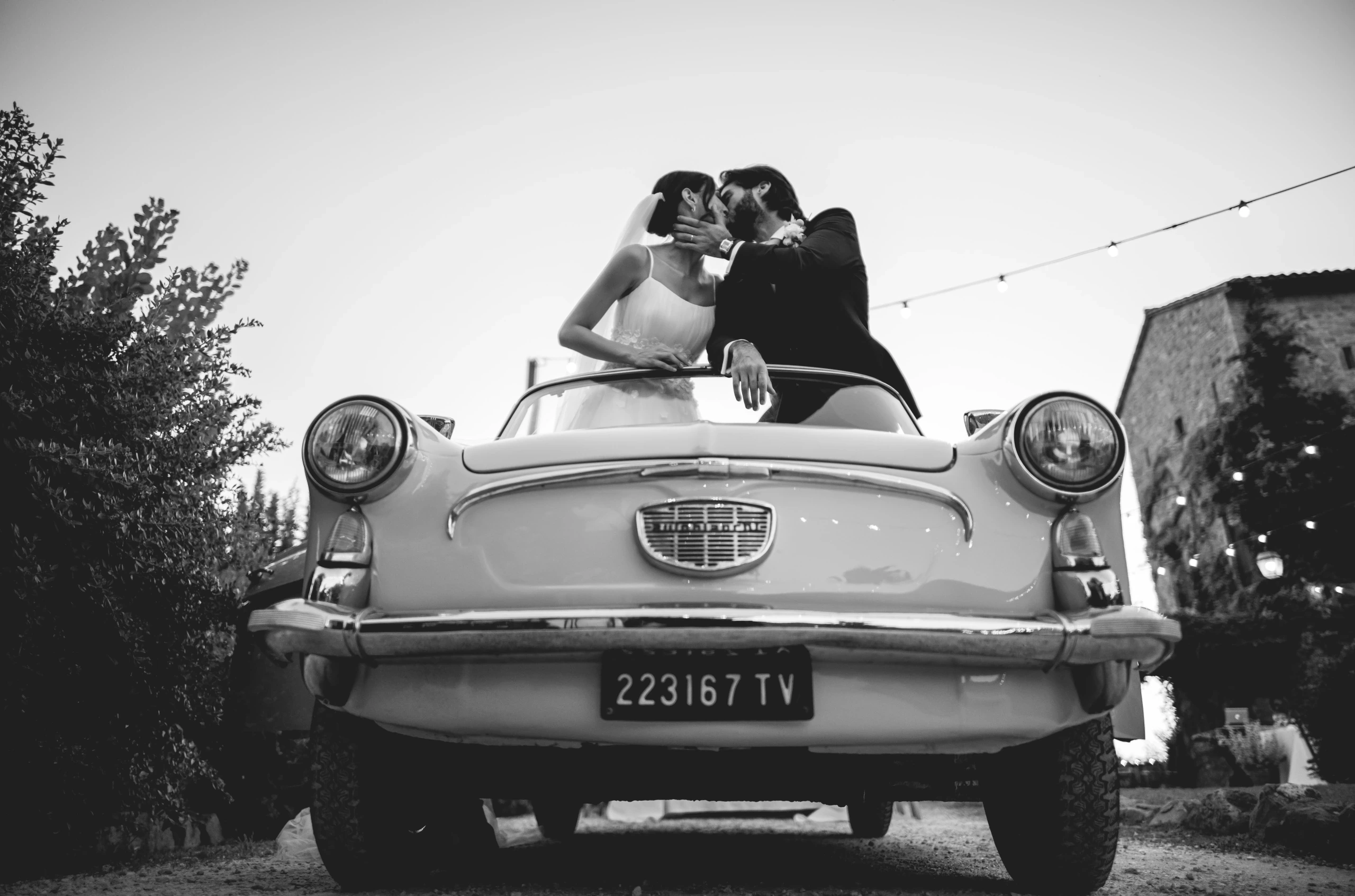 Standing in the vintage convertible, the couple's kiss.