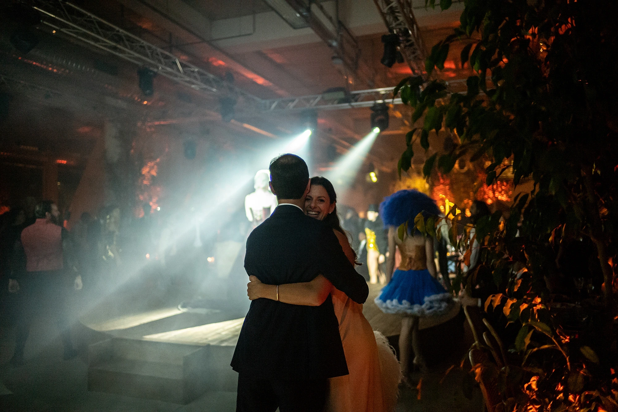 The couple's dance in a beam of light, among the plants.