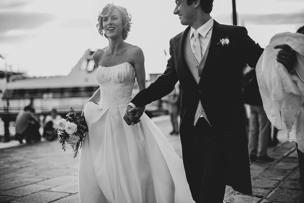 They walk hand in hand along the waterfront.