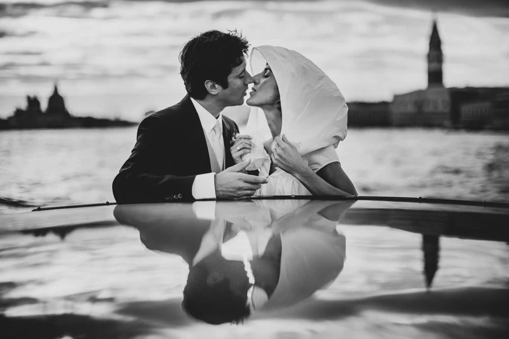 A kiss on the boat in the lagoon, reflected in the roof.