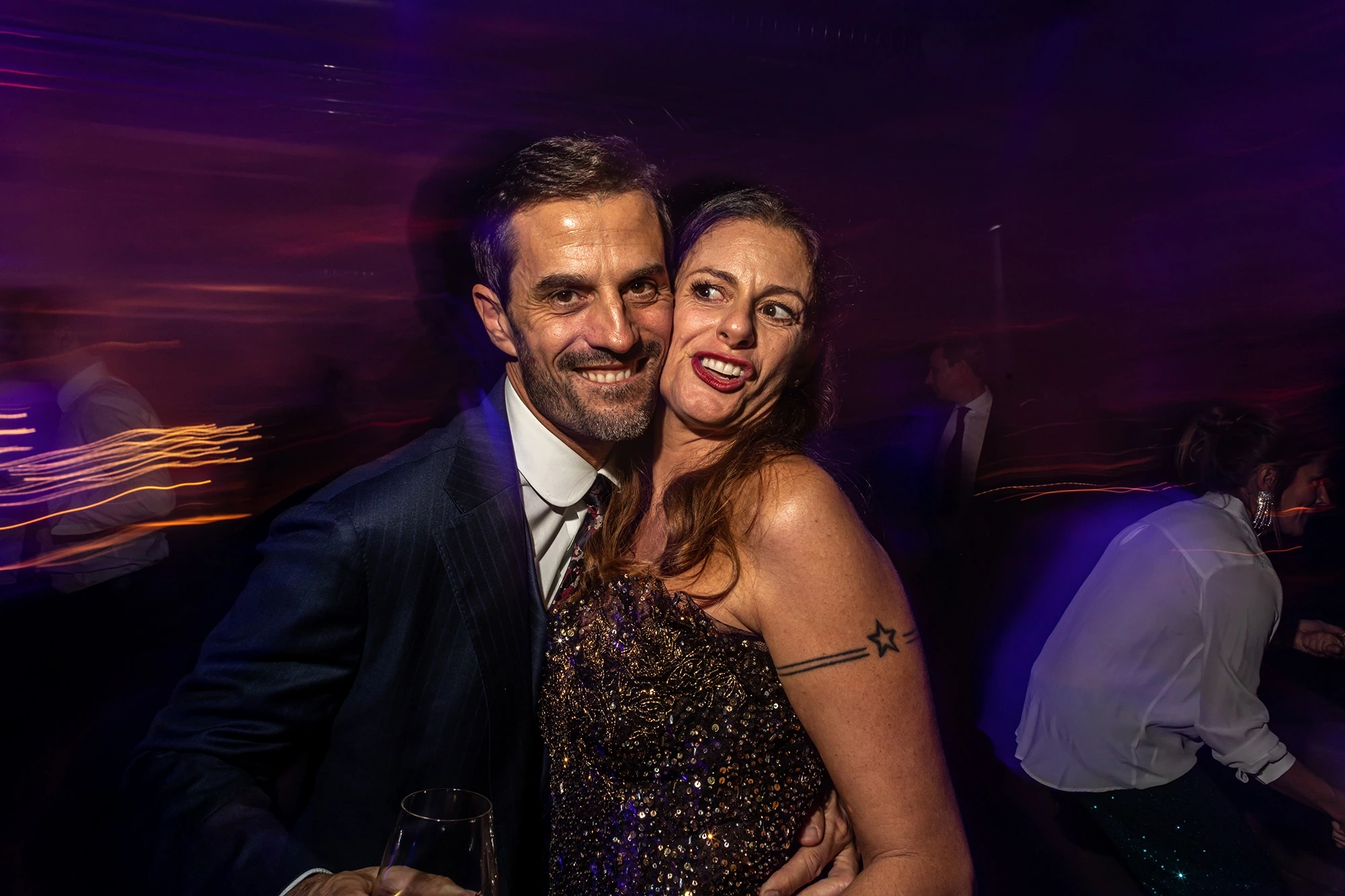 On the dance floor, a couple laughing among the blurred lights.
