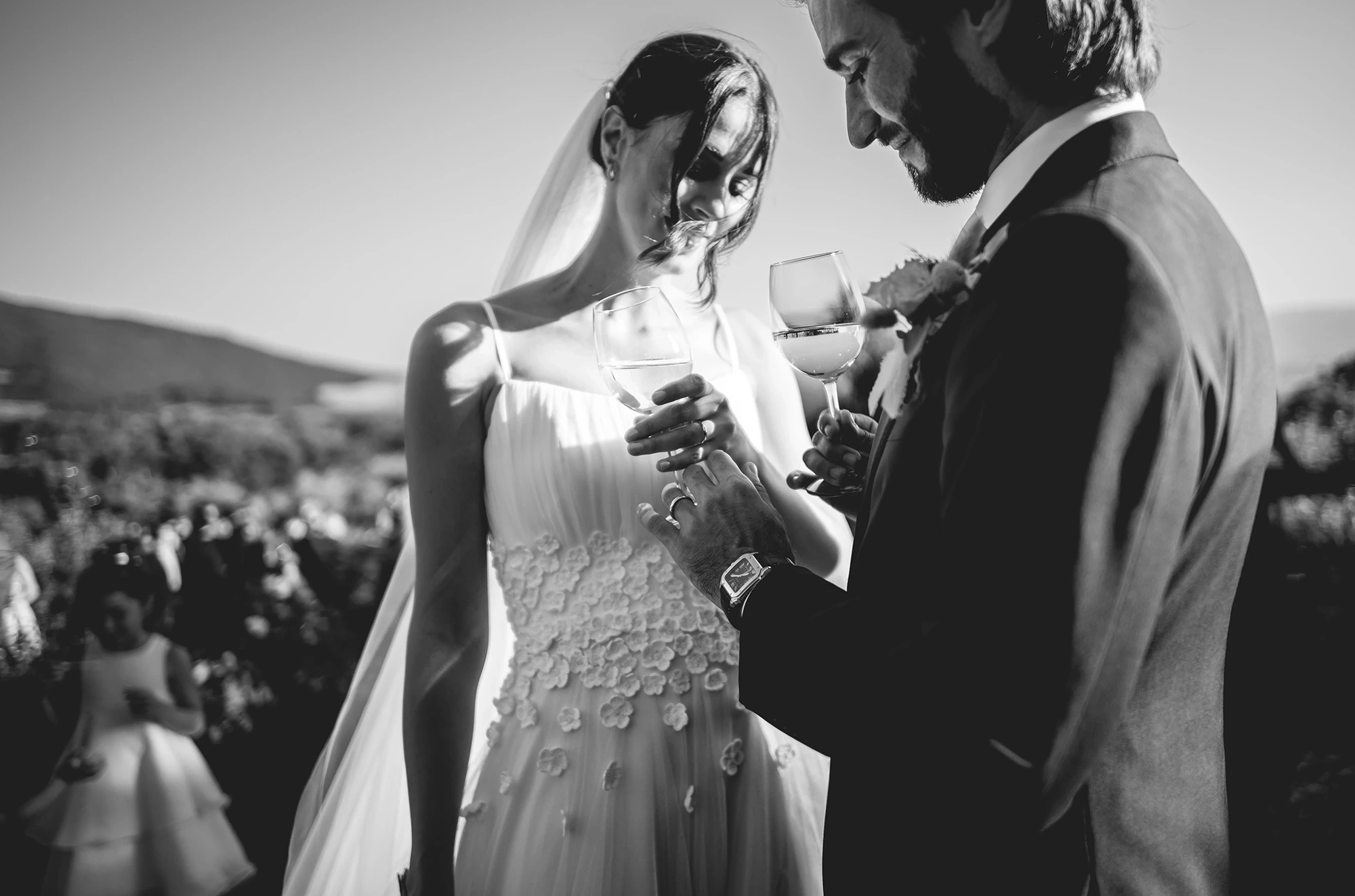 Glasses in hand, close together among the guests.