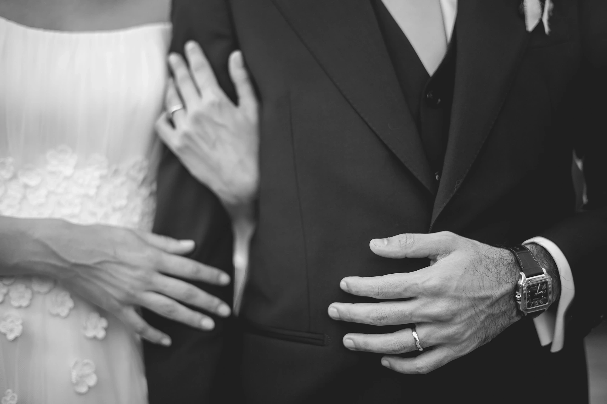 Hands at her waist, between the tulle and the jacket.