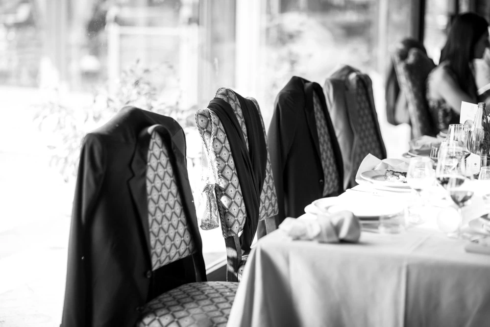 At the table, the jackets hung over the chair backs.