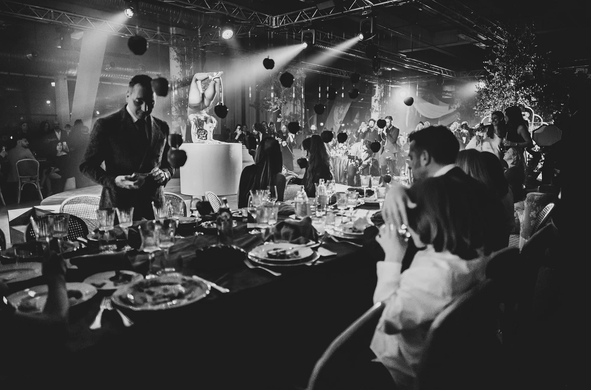 The cake at the centre of the table, among guests and lights.
