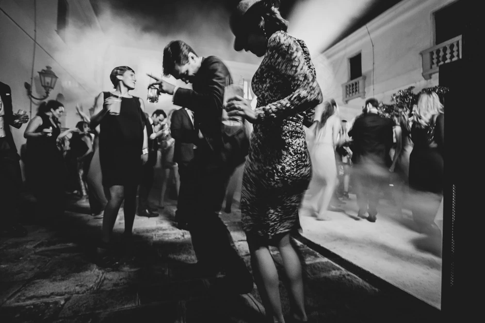 In the courtyard, the guests dance at night.
