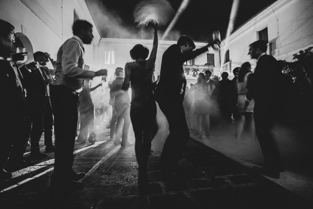 Silhouettes dancing in smoke and hard light.
