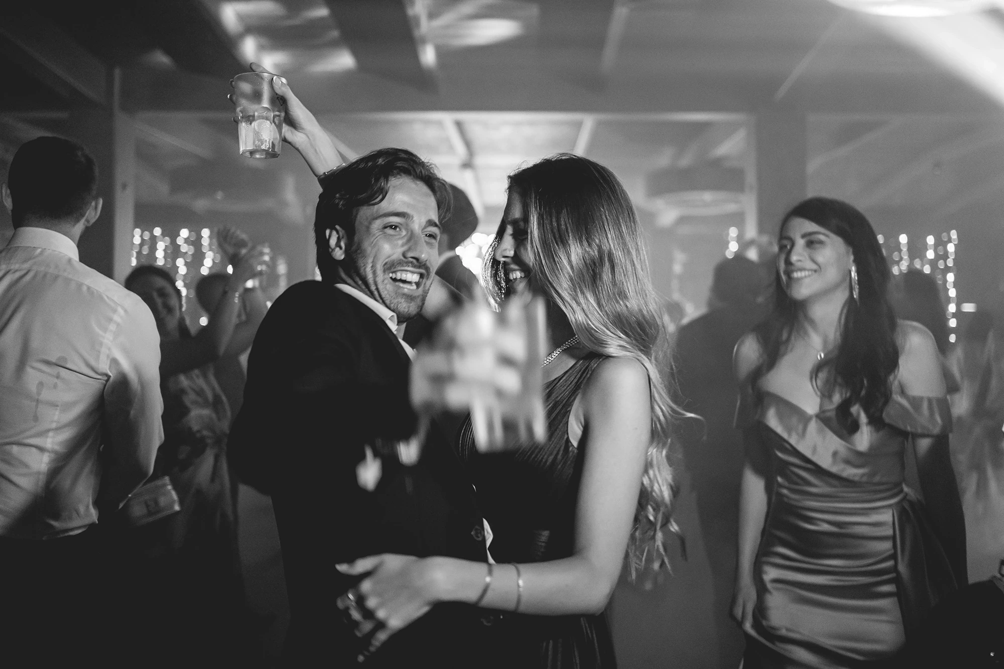 On the dance floor, a glass raised among the dancers.