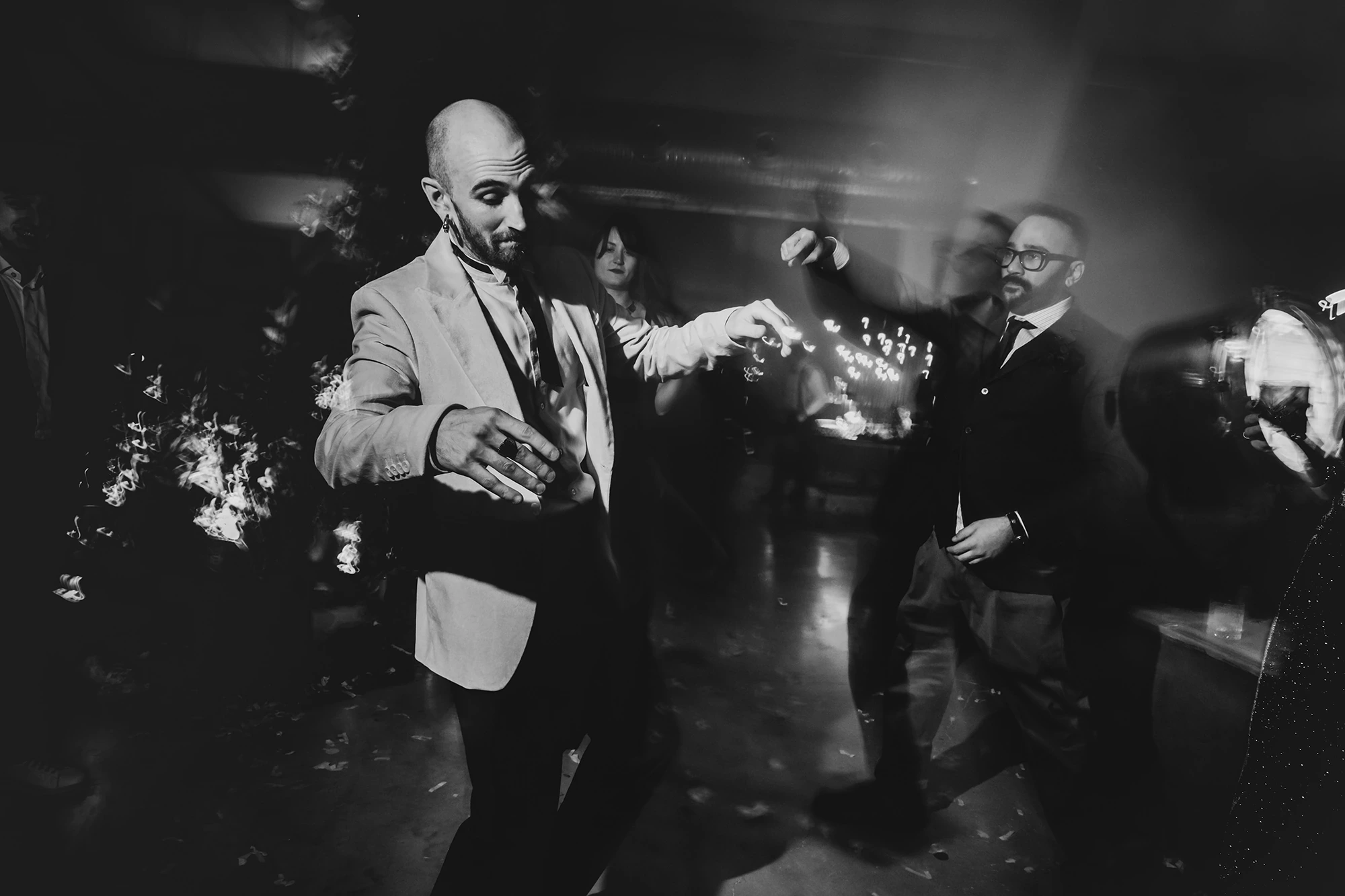 In the lit garden, the guests dance.
